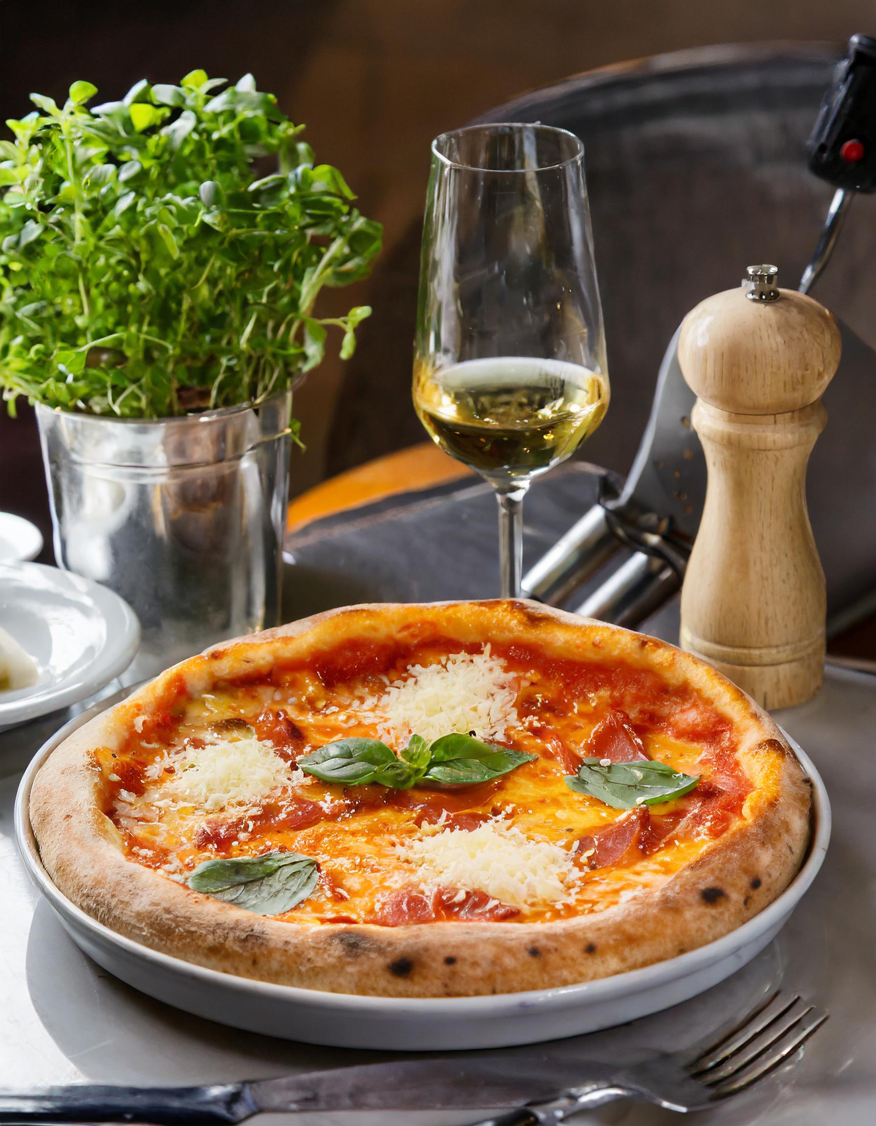 Frische, gebackene Pizza mit Tomaten und Basilikum